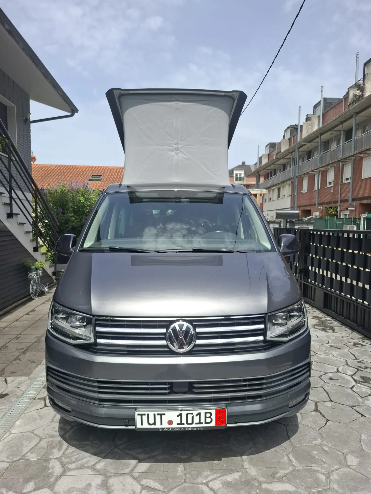 Furgoneta Volkswagen gris con el techo elevable abierto